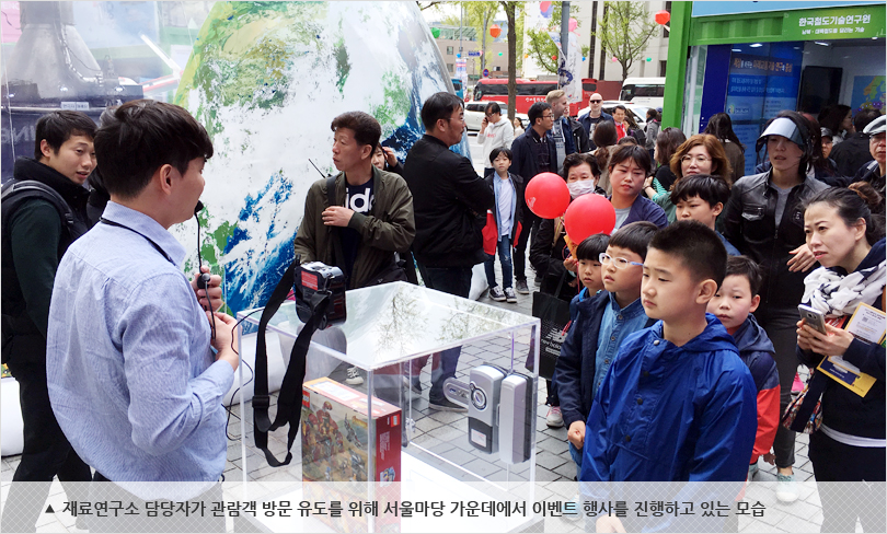 재료연구소 담당자가 관람객 방문 유도를 위해 서울마당 가운데에서 이벤트 행사를 진행하고 있는 모습